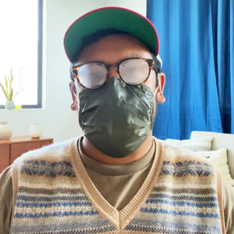 Person wearing fogged-up glasses and a green face mask