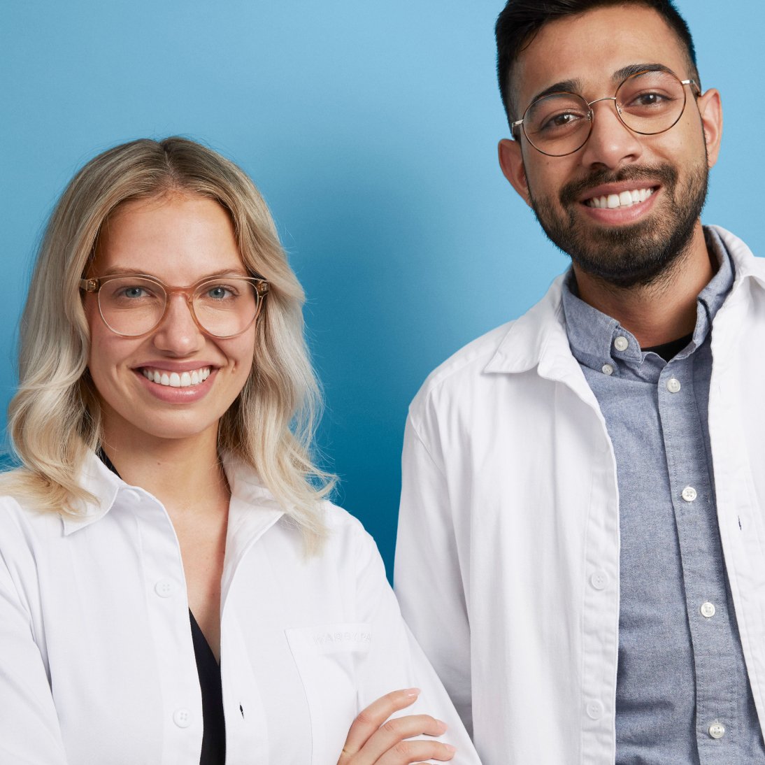 Two smiling optometrists in white coats