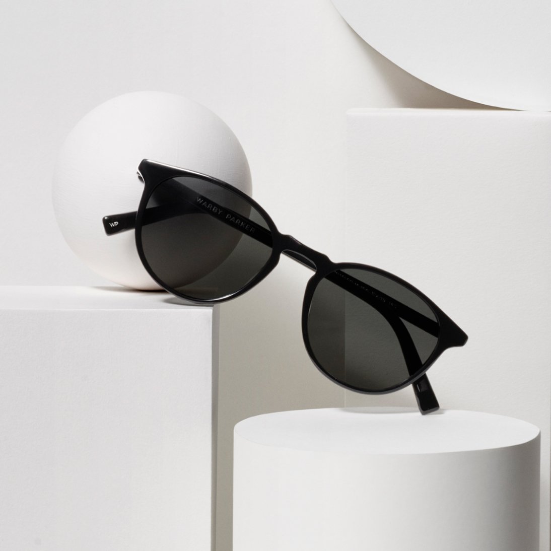 Sunglasses balanced on white geometric shapes