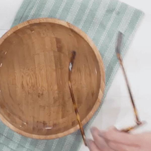 Gif of hands dipping glasses into a bowl of water and adjusting the frames to be less crooked