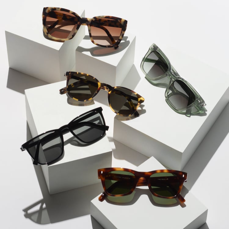 Five pairs of sunglasses sitting on white square blocks