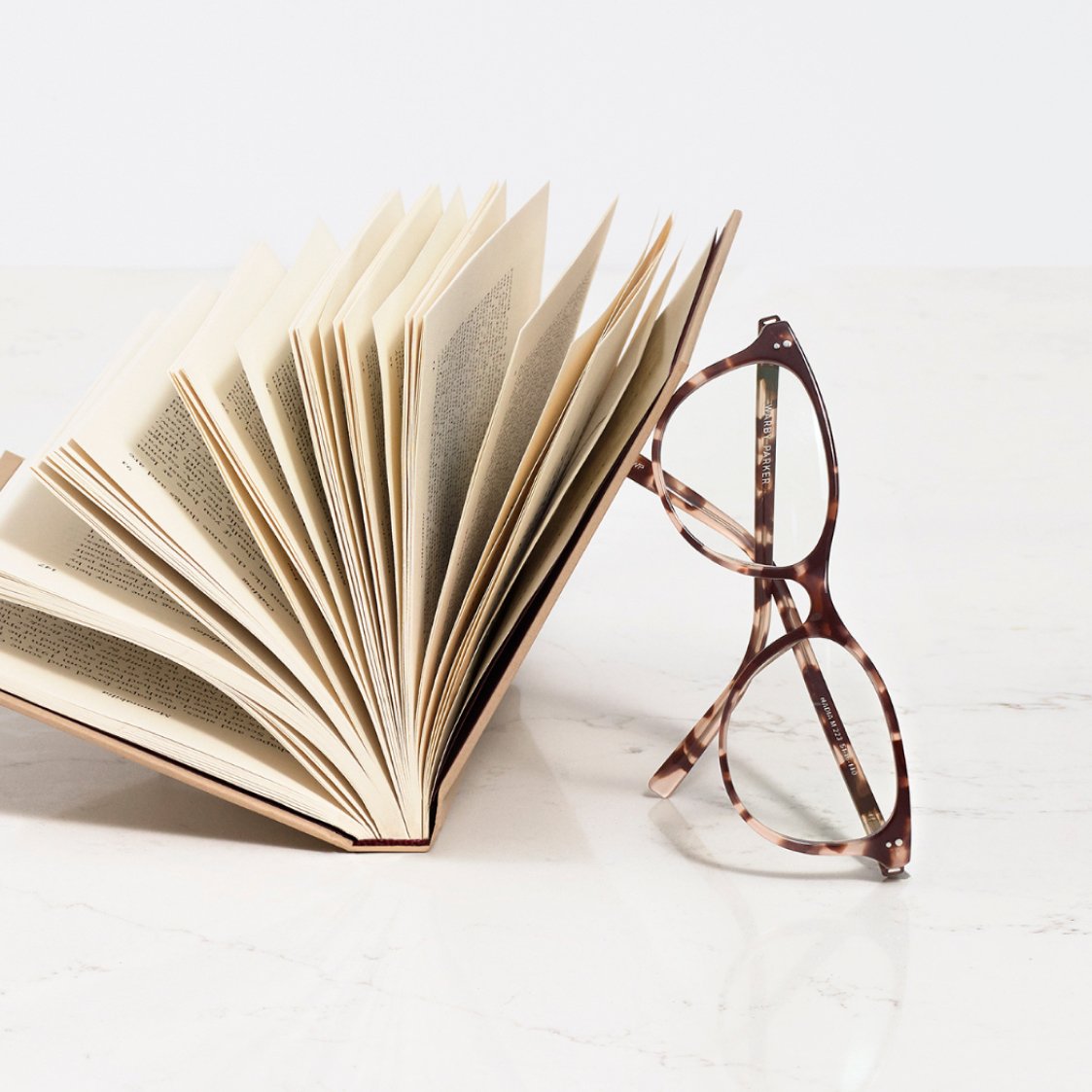 a pair of glasses leaning against a book