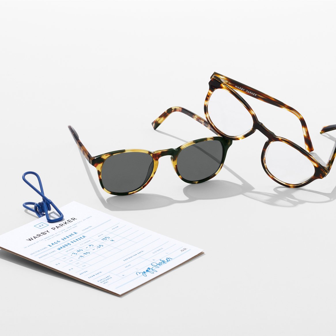 Glasses and sunglasses alongside prescription paperwork