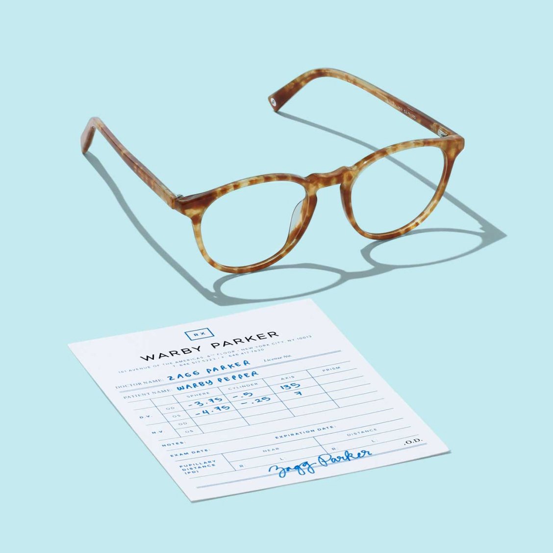 A pair of glasses next to an eye prescription