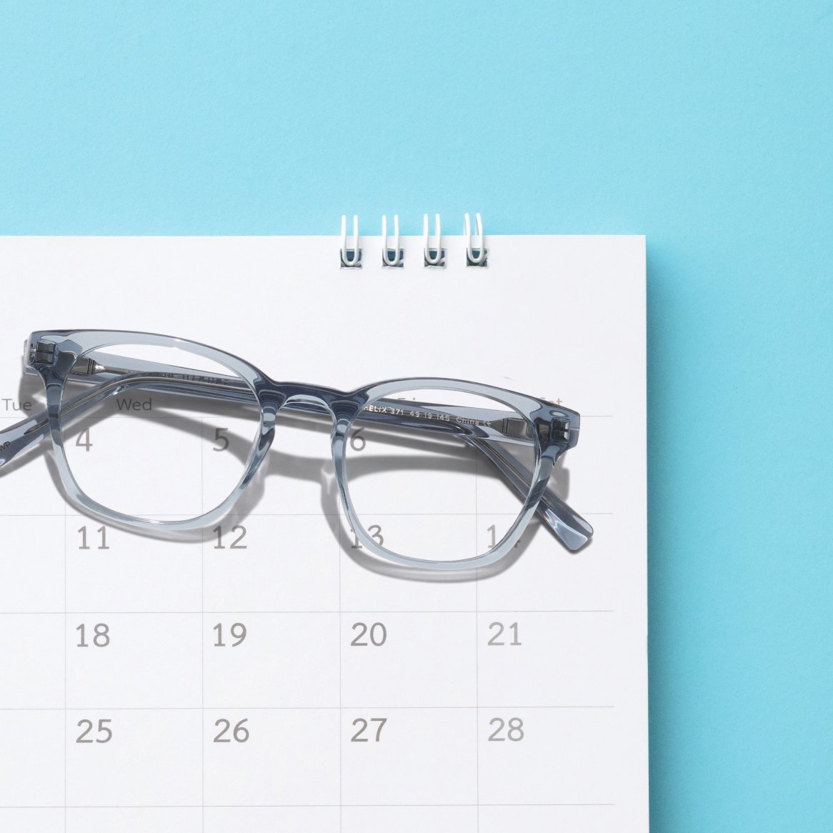 A pair of glasses on top of a calendar