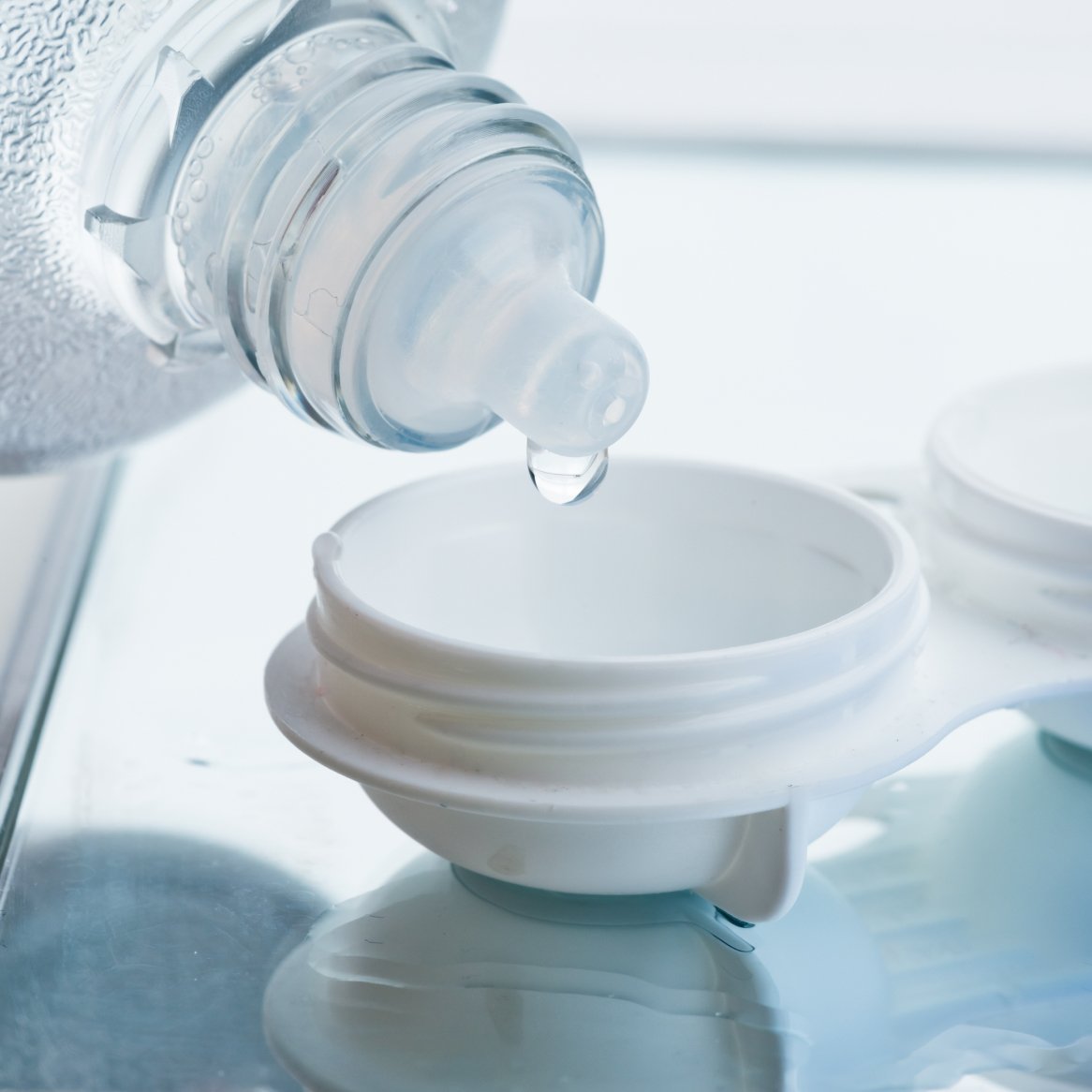 Photo of contact solution being poured into a contact storing case