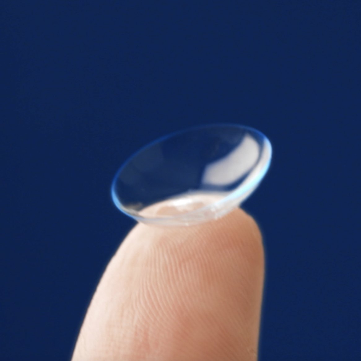 Close-up image of a contact lens on a person's fingertip