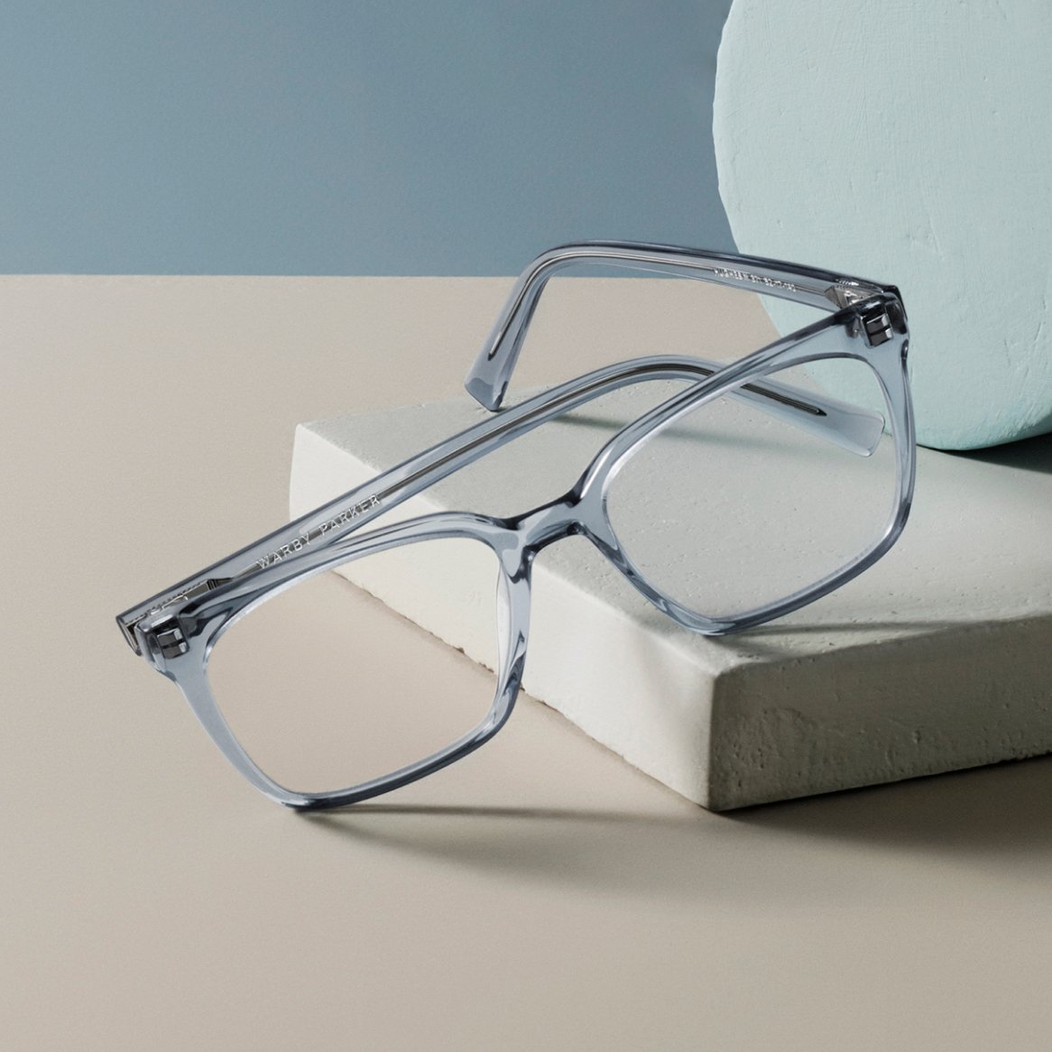 A pair of eyeglasses on a grey block