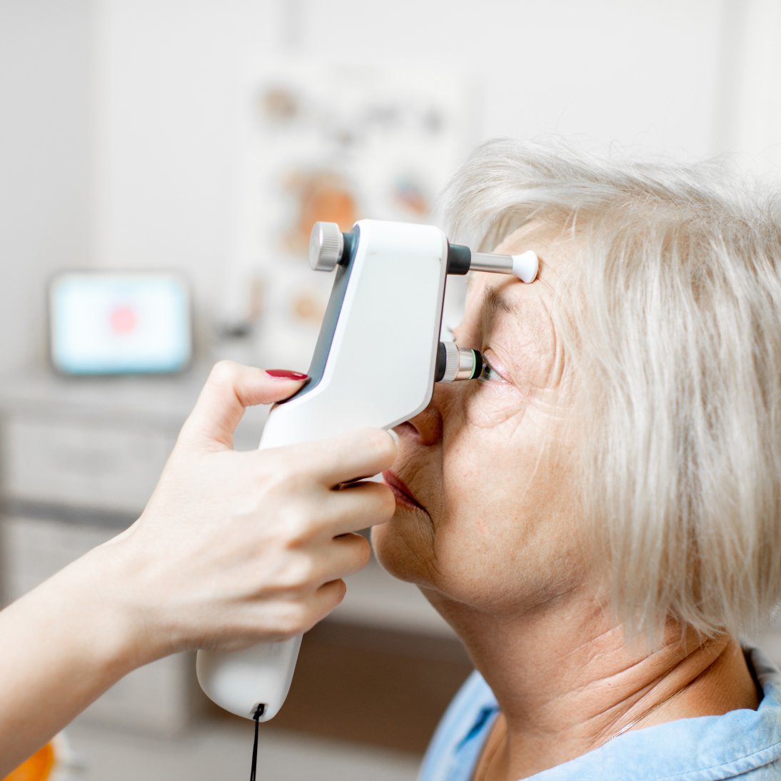 An optometrist using a tonometer to measure intraocular pressure